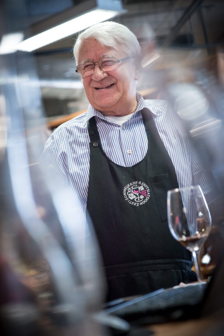 Veinimeister veiniklaasi taga. Ametifoto pildistamine